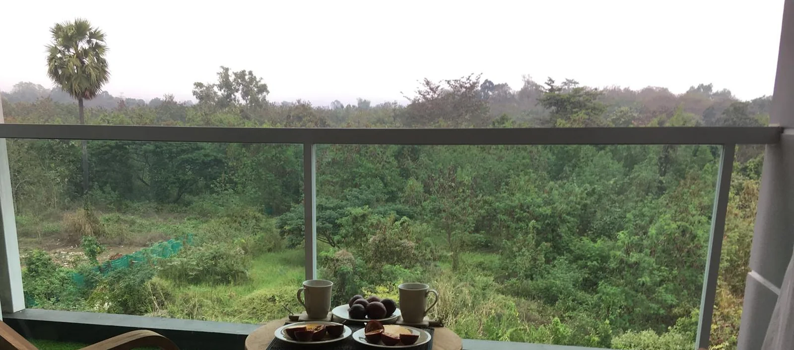 The view from the unit: green valley and misty foothills west of Chiang Mai, seen from the balcony.