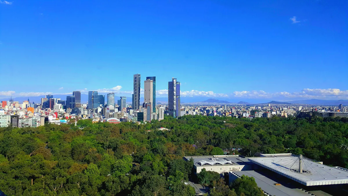 Mexico City skyline beyond Chapultepec Park: the taxes a foreign owner meets in Mexico