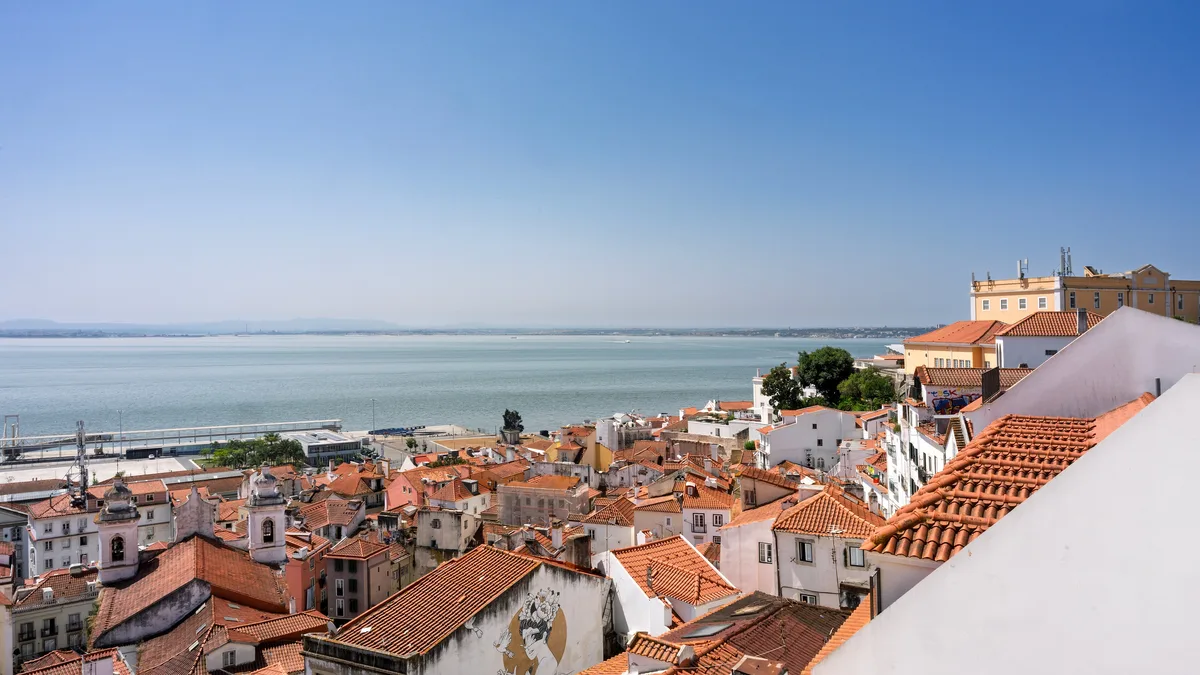 Terracotta rooftops of Lisbon's Alfama, where owners pay annual IMI on the tax value