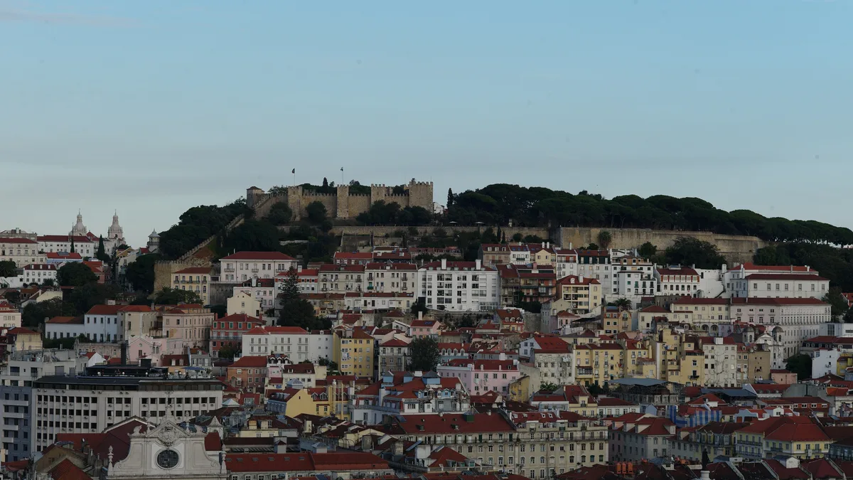 Lisbon apartment buildings below São Jorge castle, each recorded in the Land Registry and on a tax card